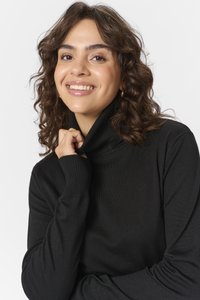 Black turtleneck sweater with a ribbed cuff and collar, made from a soft, textured fabric. Fit is relaxed and slightly loose.