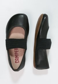 Schwarze Leder-Mary-Jane-Flatschuhe mit elastischem Riemen und brauner Sohle, einer von oben und der andere von der Seite betrachtet.