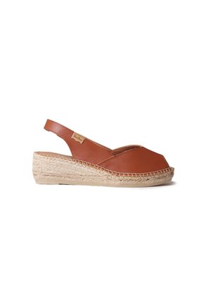 Bruine leren espadrille met een afgeronde neus, slingback-ontwerp en een gevlochten jute plateauzool. Gladde textuur, minimale merkdetails.