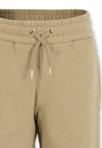 Beige trainingsbroek met een elastische tailleband, gouden oogjes en een trekkoord, met geborduurde "Chloé" branding aan de zijkant.