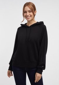 Sudadera con capucha negra de tejido suave y corte relajado, con un bolsillo canguro en la parte delantera y cordones en la capucha.
