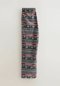 Czarne spodnie z powtarzającym się wzorem białych kufli piwa, płatków śniegu i czerwonych pasków z napisem "GUINNESS" w świątecznym wzorze.