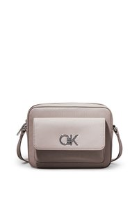 Kabelka přes rameno Calvin Klein v béžové a taupe barvě. Má hladký přední panel s logem a texturovaný zadní panel. Nastavitelný popruh a zipové zapínání.