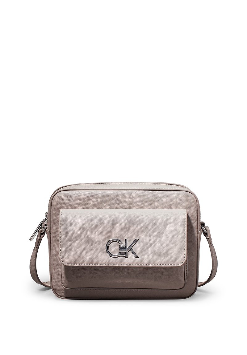 Kabelka přes rameno Calvin Klein v béžové a taupe barvě. Má hladký přední panel s logem a texturovaný zadní panel. Nastavitelný popruh a zipové zapínání.