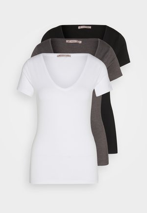 Tre V-ringade t-shirts i vitt, grått och svart. Varje t-shirt har korta ärmar, en figursydd design och är tillverkad av ett mjukt tyg.
