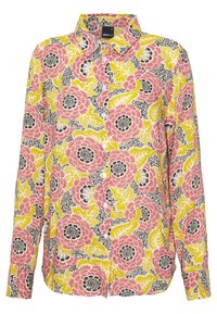 Camisa de botones con estampado floral que presenta patrones en rosa, amarillo y negro sobre un fondo blanco. Fabricada con un tejido ligero y con cuello.