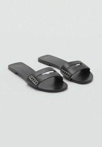 Sandale negre cu talpă plată, realizate dintr-un material neted, având o curea superioară lată cu o decupare și detalii metalice.