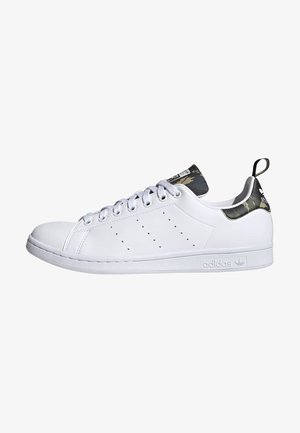 Biały tenis Adidas Stan Smith z detalami kamuflażu na zapiętku i języku, z zapięciem na sznurówki i perforowanymi bocznymi paskami.