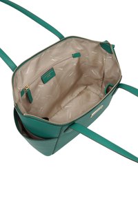Tote bag en cuir vert avec un intérieur beige, fermeture éclair, bretelles réglables et plusieurs poches intérieures.