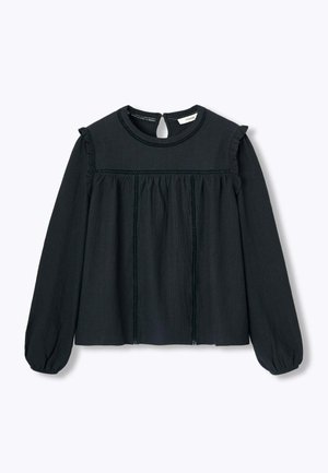 Haut noir à manches longues avec un col rond, des accents à volants sur les épaules et un tissu texturé présentant des coutures verticales et une ouverture arrière.