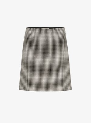 Sorte og hvide skørter med houndstooth-mønster i en lige skæring, glat tekstur og livrem. Fremstillet af stof, uden synlig hardware.
