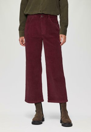 Bordeaux corduroy broeken met een relaxte pasvorm, voorzien van een voorzakken en een knoopsluiting, gedragen met bruine enkelboots.