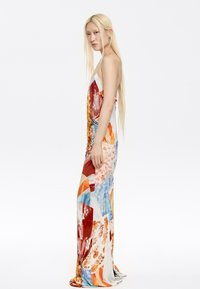 Maxi-jurk met een mix van levendige kleuren en bloemmotieven. Gemaakt van lichte stof met verstelbare bandjes en een vloeiende silhouet.