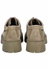 Scarpe in suede beige con retro arrotondato, dotate di un esterno testurizzato e suole in gomma spesse. Nessun logo visibile o hardware aggiuntivo.