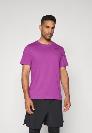 Lilla atletisk t-shirt lavet af glat stof, med rund halsudskæring og et lille sort logo på venstre bryst. Sorte shorts.