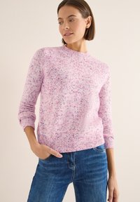 Jasnoróżowy sweter z dzianiny z okrągłym dekoltem, długimi rękawami oraz ściągaczami przy mankietach i u dołu, z delikatnymi nakrapianymi wzorami w ciemniejszym odcieniu różu i fioletu.