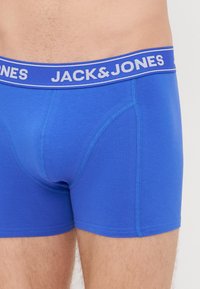 Boxer in cotone blu con vita in elastico brandizzato con la scritta "JACK & JONES." Presentano una texture liscia e dettagli di cucitura a contrasto.