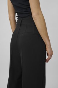 Black wide-leg trousers with a smooth texture, featuring a fitted waistband, two back pockets, and a clean seam design.