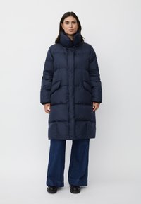 Cappotto imbottito blu navy con colletto alto, due tasche frontali e design trapuntato. Il materiale appare liscio con una texture leggera.