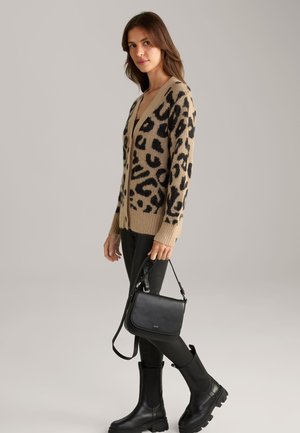 Beige Cardigan mit schwarzem Leopardenmuster, gerippten Kanten, kombiniert mit einer schwarzen Lederhandtasche und eleganten schwarzen kniehohen Stiefeln.