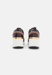 Black sneakers featuring a leopard print fabric band, patent leather accents, gold detail on the heel, and a white sole with a textured finish.