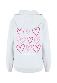 Felpa bianca con un motivo a cuori rosa sul retro, con il testo "FIDATI DEL TUO CUORE" in nero. Realizzata in tessuto morbido con vestibilità rilassata.