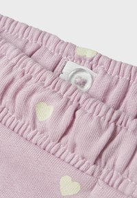Pink bomuldsbeklædning med elastisk talje, der har hvide hjerte mønstre. Bemærkelsesværdig knaplukning og flæset kanter. Blød tekstur.