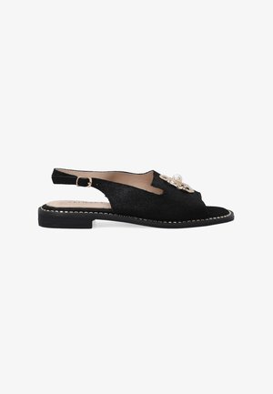 Sort slingback sandal lavet af tekstureret materiale med en dekorativ perle- og ædelstensaccent, med en slank sort sål og guldtråde.