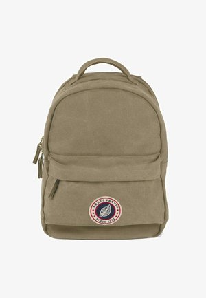 Sac à dos en toile kaki avec une forme arrondie, poche zippée à l'avant et un patch logo circulaire. Il dispose de doubles poignées supérieures et d'un tissu texturé.