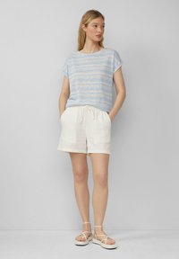 Blauw en crème gestreepte kortemouwen top gecombineerd met witte shorts met trekkoord en lichtgekleurde sandalen. Casual, ontspannen pasvorm en textuur.