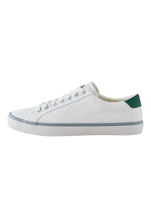 Pantof sport alb, cu talpă joasă, din pânză, șireturi albe, o tabă verde la călcâi și o dungă gri de-a lungul tălpii, văzut din lateral.