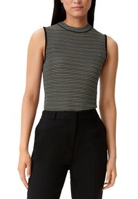 Czarnobiały bezrękawnik z teksturowanym wzorem dzianiny, wysokim kołnierzem i dopasowanym krojem, w zestawieniu z czarnymi, wysokim stanem spodniami.