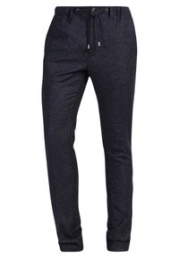 Marinblå joggerbyxor med ett prickigt mönster, dragsko i midjan och avsmalnande ben med elastiska mudd. Tillverkade av ett material som andas.