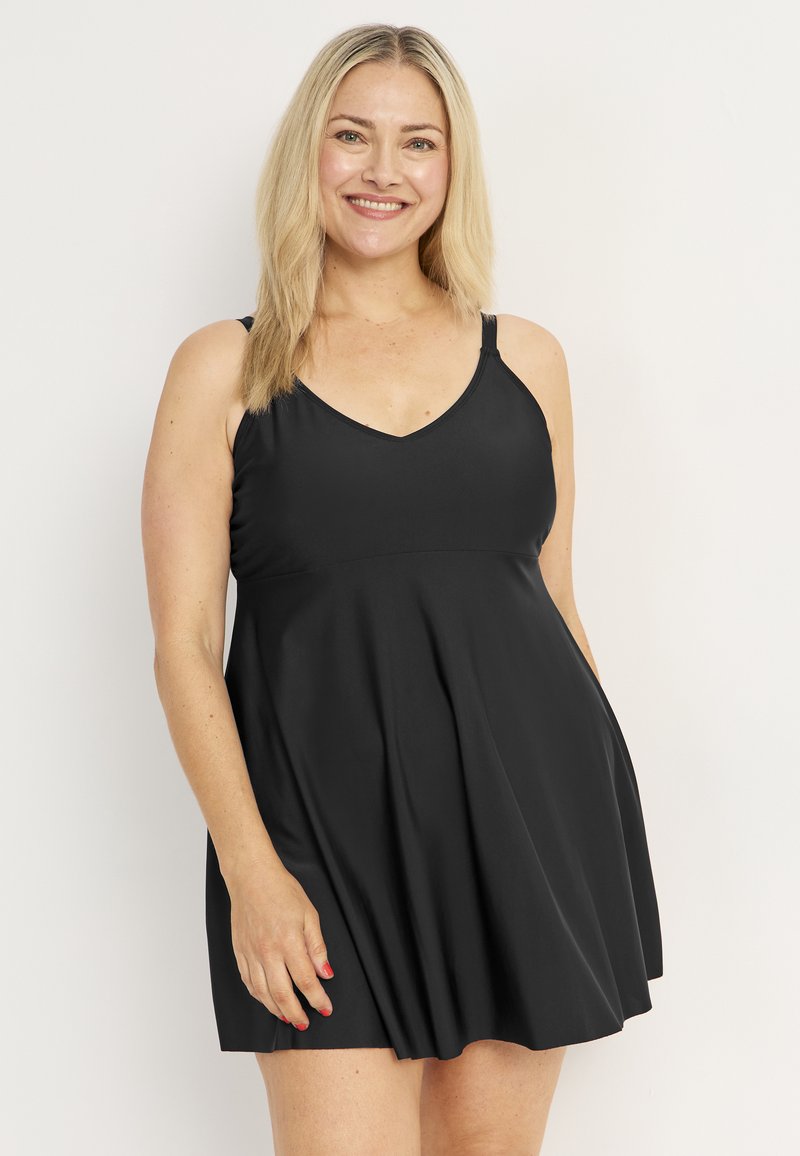 Mekko, jossa on säädettävät ohuet olkaimet, V-mallinen kaula-aukko, irtonainen A-linjan muoto ja pehmeä, sileä kangas.