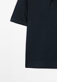 Tmavě modré polo tričko s krátkými rukávy, límečkem a hladkou texturou se rovnými lemy. Minimalistický design bez vzorů.