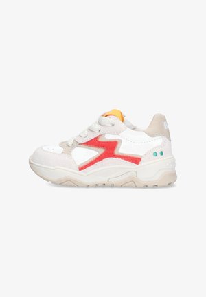 Witte en beige sneaker met rode zigzag-zijdetail, beige zool, witte veters en oranje tonglabel op een witte achtergrond.