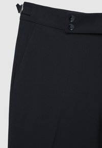 Schwarze Hosen mit glatter Textur, ausgestattet mit einem breiten Bund und zwei Knopfverschlüssen. Enthält Seitentaschen und einen Gürtelschlaufen.