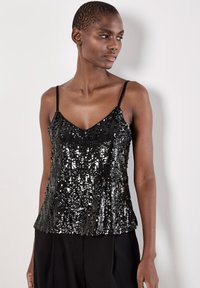 Schwarzes, mit Pailletten besetztes Camisole mit dünnen Trägern, das einen V-Ausschnitt und einen fließenden, leicht gerüschten Saum aufweist. Strukturierte Oberfläche mit funkelnden Details.
