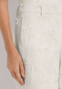 Witte geborduurde broek met bloemenpatronen, een soepel textuur en een op maat gemaakte ontwerp met een nette tailleband en zijzak.