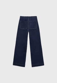 Pantalones de mezclilla anchos de color azul oscuro con dos grandes bolsillos traseros y costuras visibles sobre un fondo gris claro.