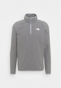 Suéter de felpa gris con cuello de media cremallera. Tiene mangas largas, un cuello alto y un logo blanco en el área del lado izquierdo del pecho. Acentos de costura horizontal.