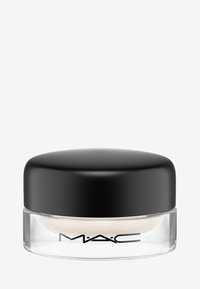 MAC-kräm i en klar glasburk med ett svart rundat lock. Texturen verkar smidig och krämen har en ljus, neutral färg.