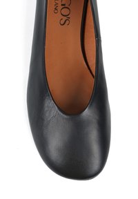 Czarne skórzane baletki z zaokrąglonym czubkiem i niskim krojem z przodu. Wnętrze jest w kolorze brązowym, z dyskretnie wrysowaną nazwą marki.