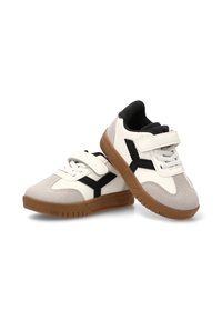Zapatillas con un upper sintético blanco, acentos de ante gris, detalles en negro y una suela de goma marrón. Cuenta con una correa de Velcro para el cierre.