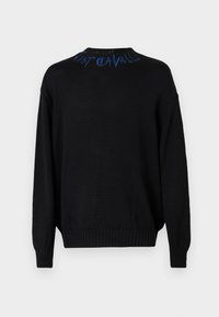 Črna pletena jopica z dolgimi rokavi in ribastimi manšetami. Ima modro izvezeno besedilo ob vratnem izrezu. Ohlapen kroj in teksturirana tkanina.