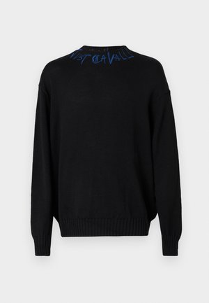 Fekete kötött pulóver hosszú ujjakkal és bordázott mandzsettákkal. Kék hímzett szöveg található a nyakvonal mentén. Lazább szabású és texturált anyagú.