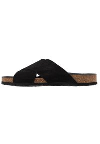 Sandali a scivolo neri in suede con cinturini incrociati, suola intermedia in sughero e suola esterna in gomma testurizzata. Design piatto con dettagli di stile minimalisti.