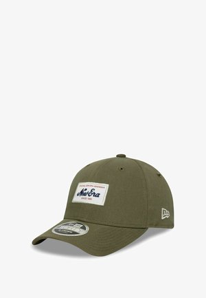Gorra de béisbol verde oliva hecha de tela, con un parche de logo en blanco y marino en la parte frontal, con un visor curvado y ojales de ventilación.