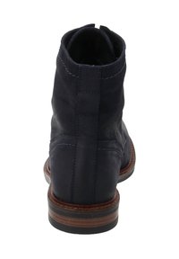Stivaletto in pelle blu navy con tacco impilato marrone, cuciture decorative e linguetta sul retro.
