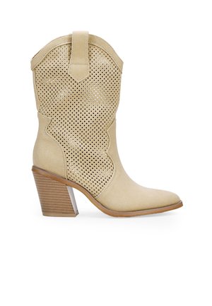Bota de cowboy de cuero beige con diseño perforado, punta afilada, parte superior curvada y tacón apilado con acentos marrones texturizados.